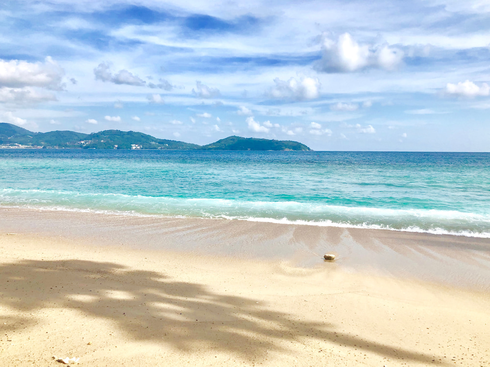 A sunny and serene photo of Nakalay Beach in Phuket.
