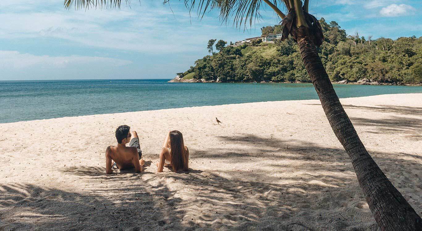 A couple relaxing on the sand at Nakalay Beach