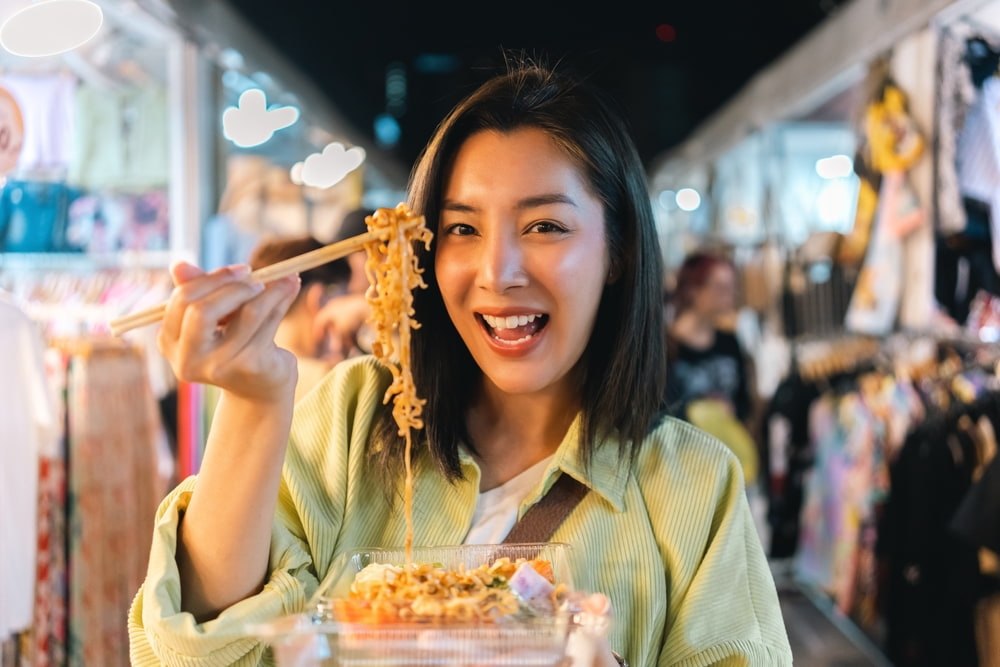 A woman enjoying food at Bangla Night Market