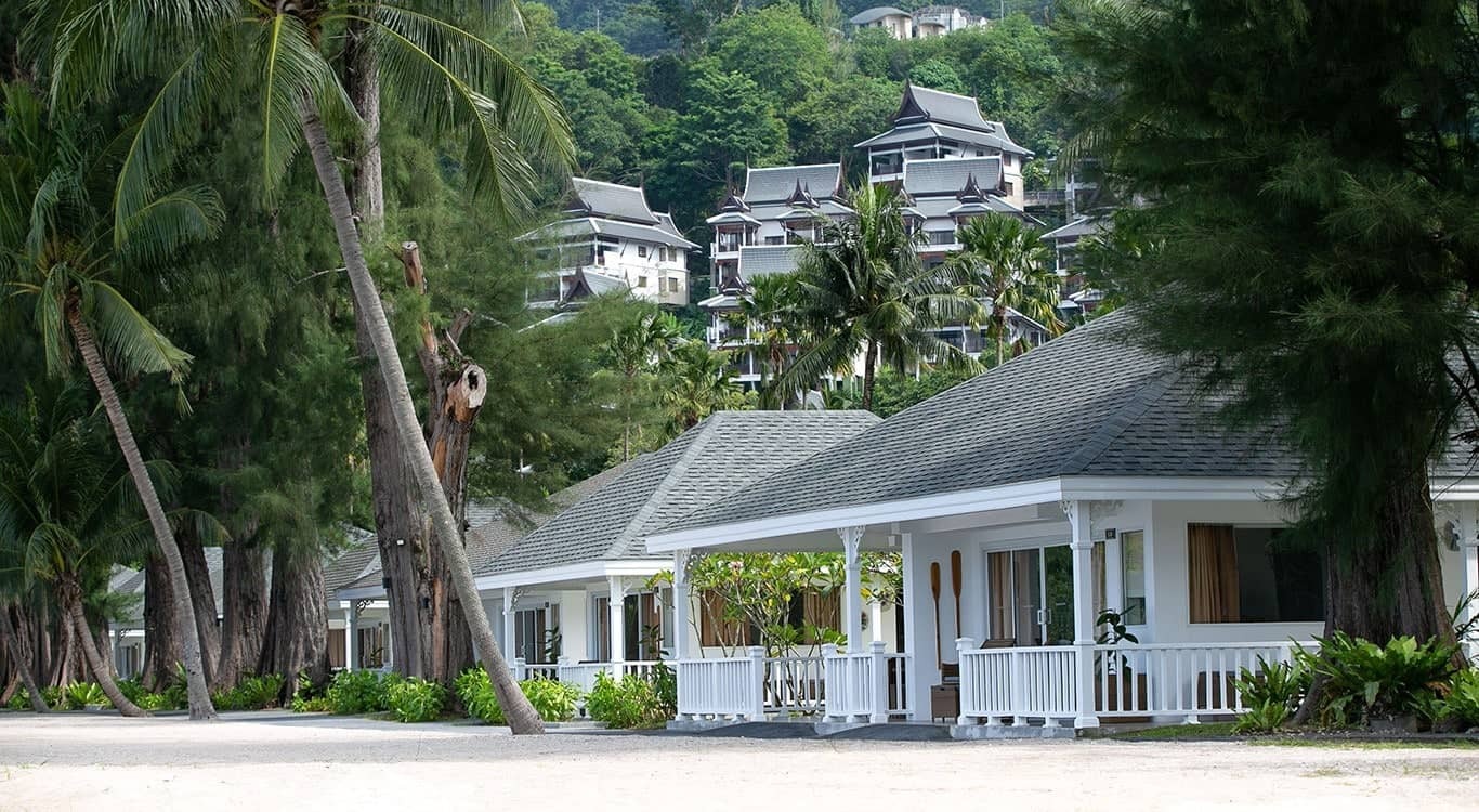 Beachfront cottages with hillside rooms as backdrop