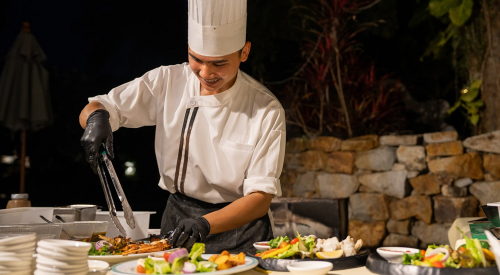Ein Koch bereitet köstliche Speisen an der Swim-up-Bar des Thavorn in Phuket zu.