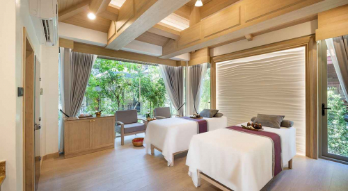 Our luxury spa treatment room in Phuket with two massage beds, soft lighting, and a garden view