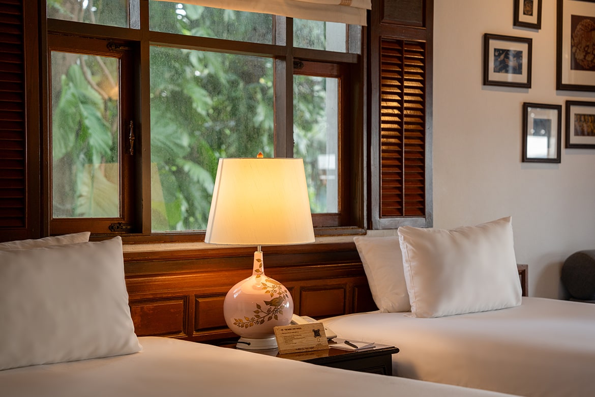 A bedroom with a view of lush greenery at our beachfront resort
